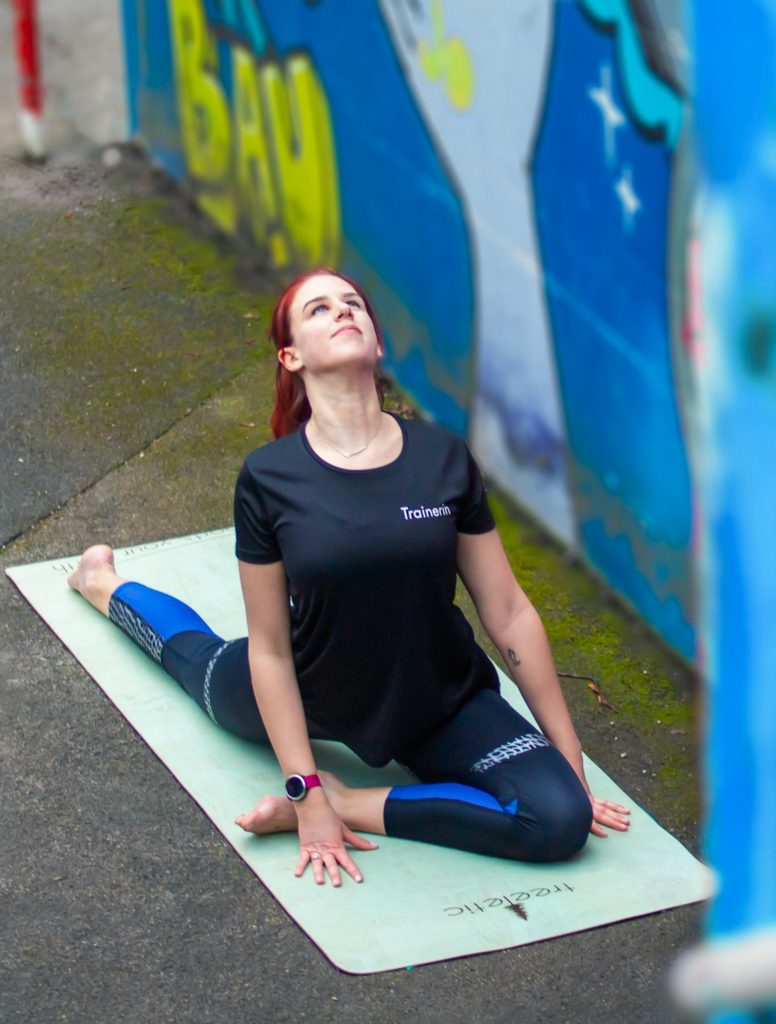 Frau beim Stretching auf Yogamatte, Online Training Stabilitäts und Mobilitätstraining